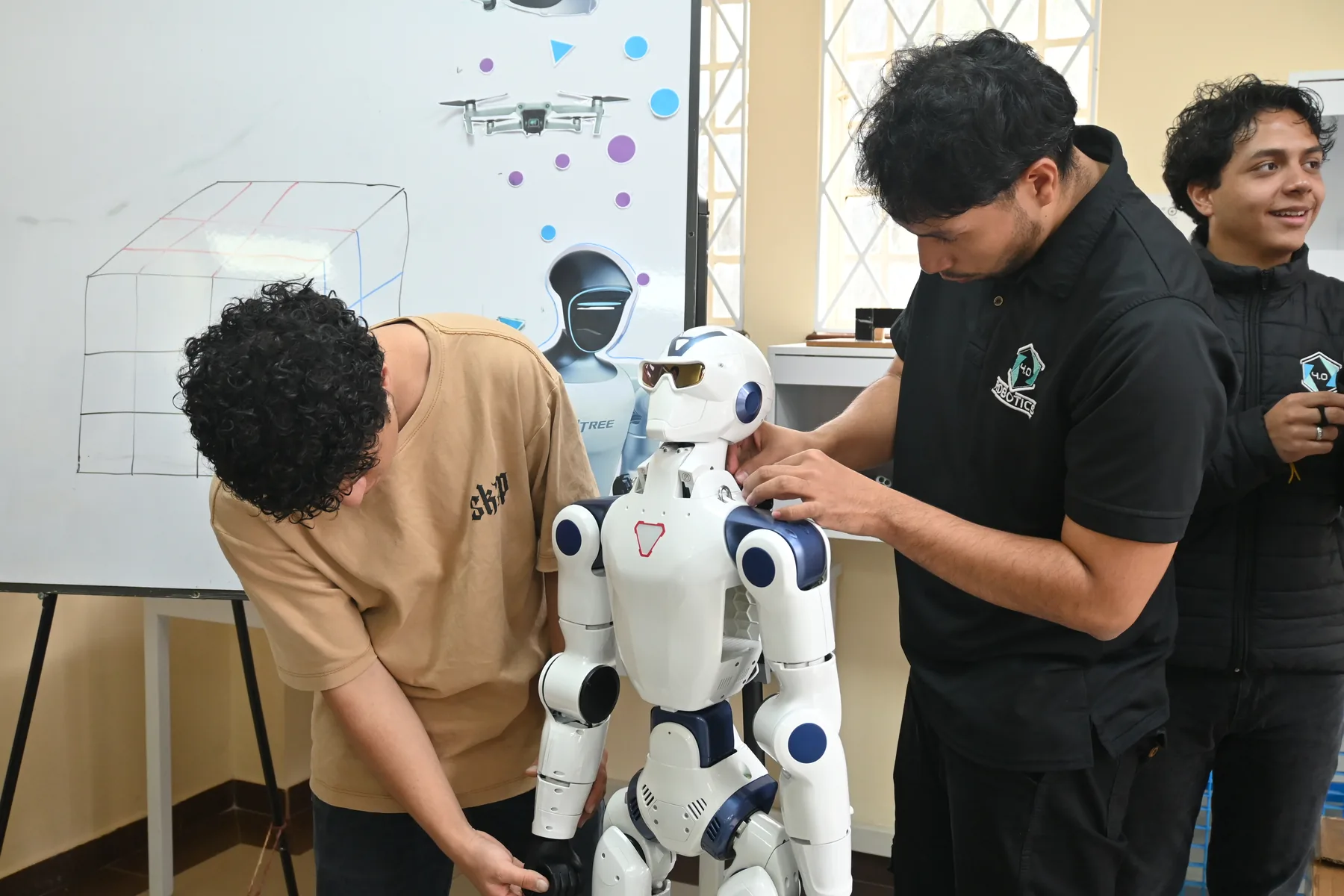 Equipo de la Universitaria de Colombia junto al robot humanoide