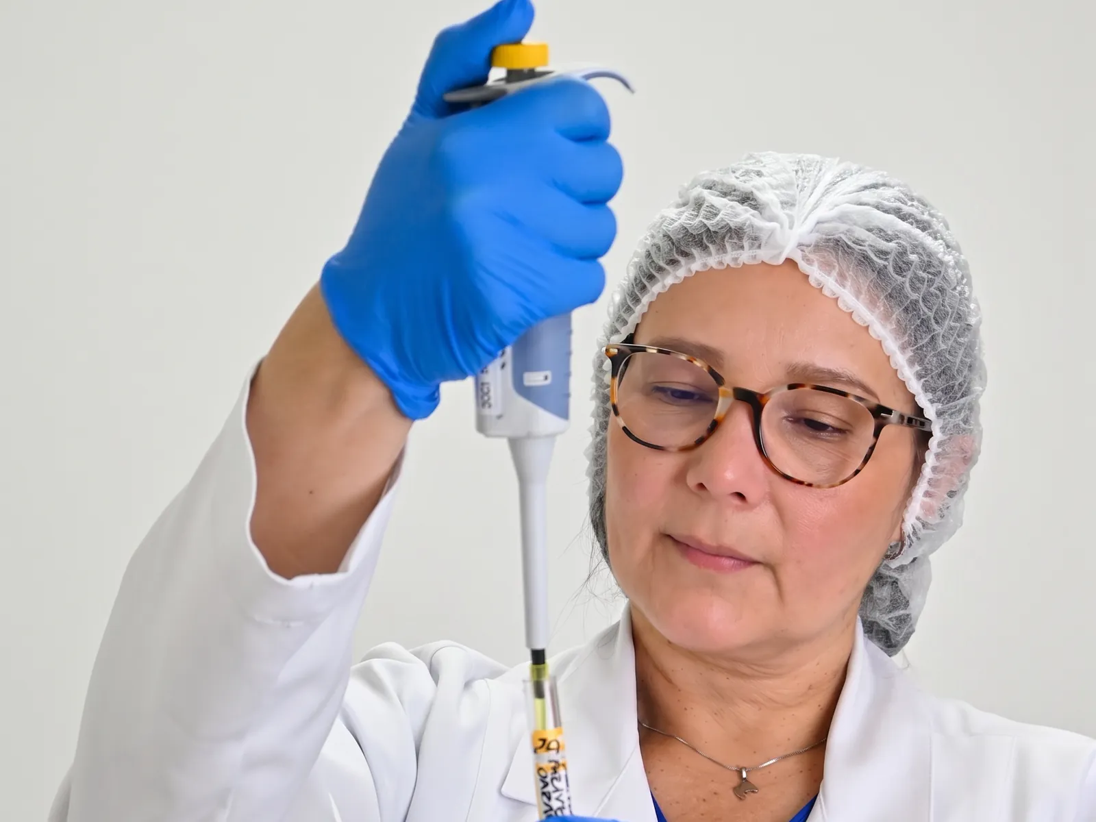 Profesional del laboratorio clínico de la IPS Universitaria de Colombia trabajando con una micropipeta